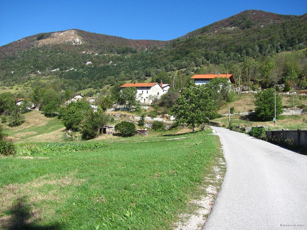 Slika_07.jpg - Pogled na vas Podkraj, vendar s ceste, ki že vodi v smeri turistične kmetije Abram in Vojkove koče na Nanosu.